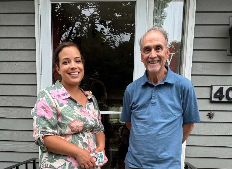 Suzy canvassing with a resident at his front door