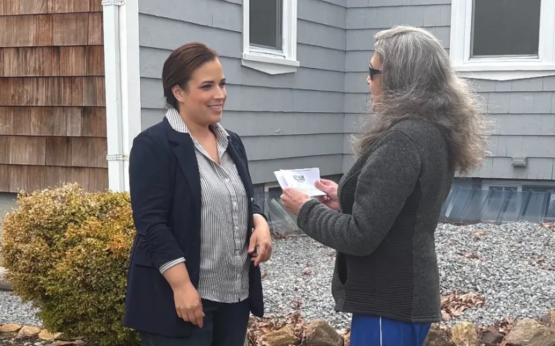 Suzy talking with a resident outside her home