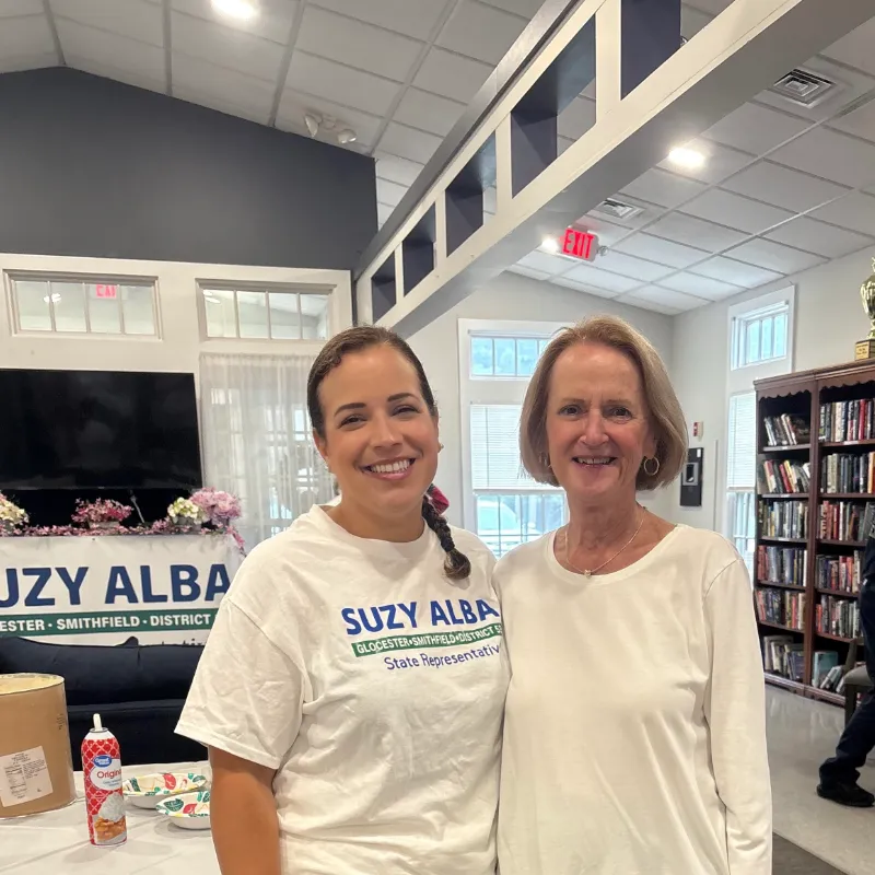 Suzy with a supporter indoors near a bookshelf
